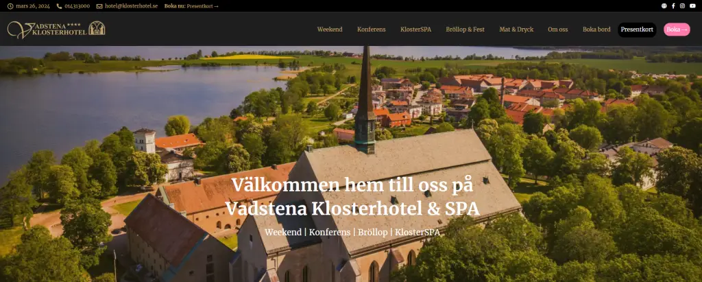 Andlös flygbild av Vadstena Klosterhotel & SPA, som fångar den lugna sjön, de lummiga omgivningarna och hotellets historiska arkitektur.