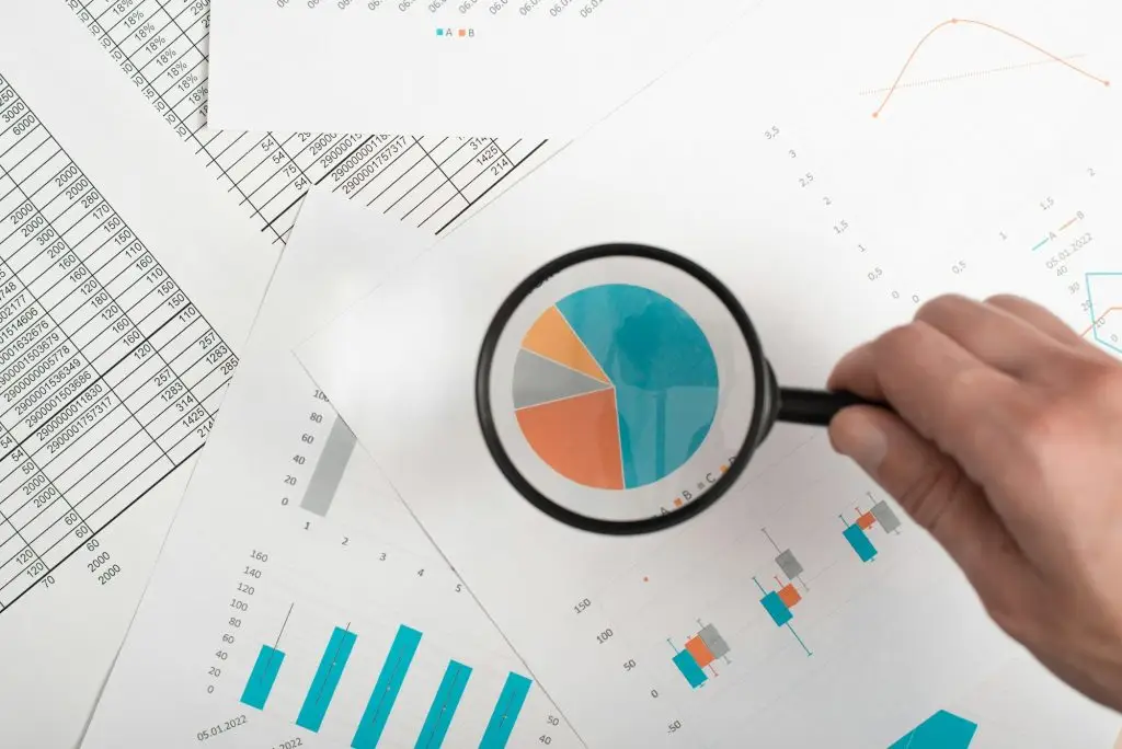 Förstoringsglas över diagram som analyserar ekonomiska indikatorer.