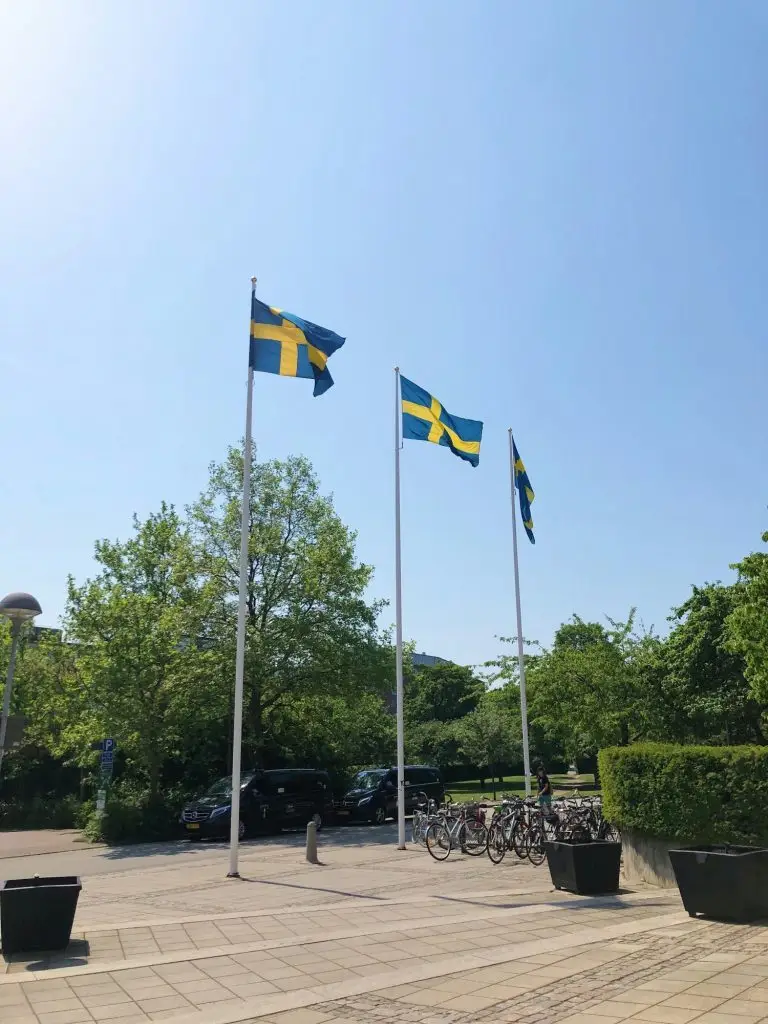 Photo of three Swedish flags and clear blue sky