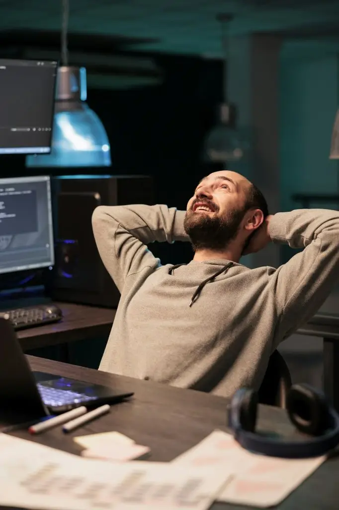 Cheerful IT engineer relaxing on office chair