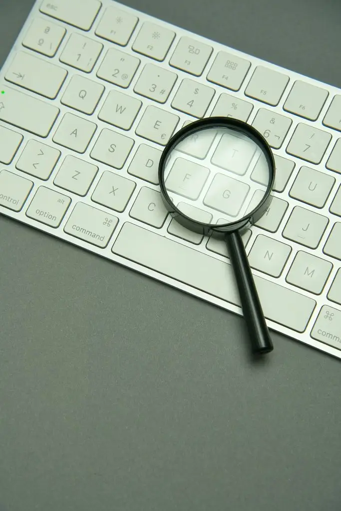 Magnifying glass and laptop keyboard. Seo.